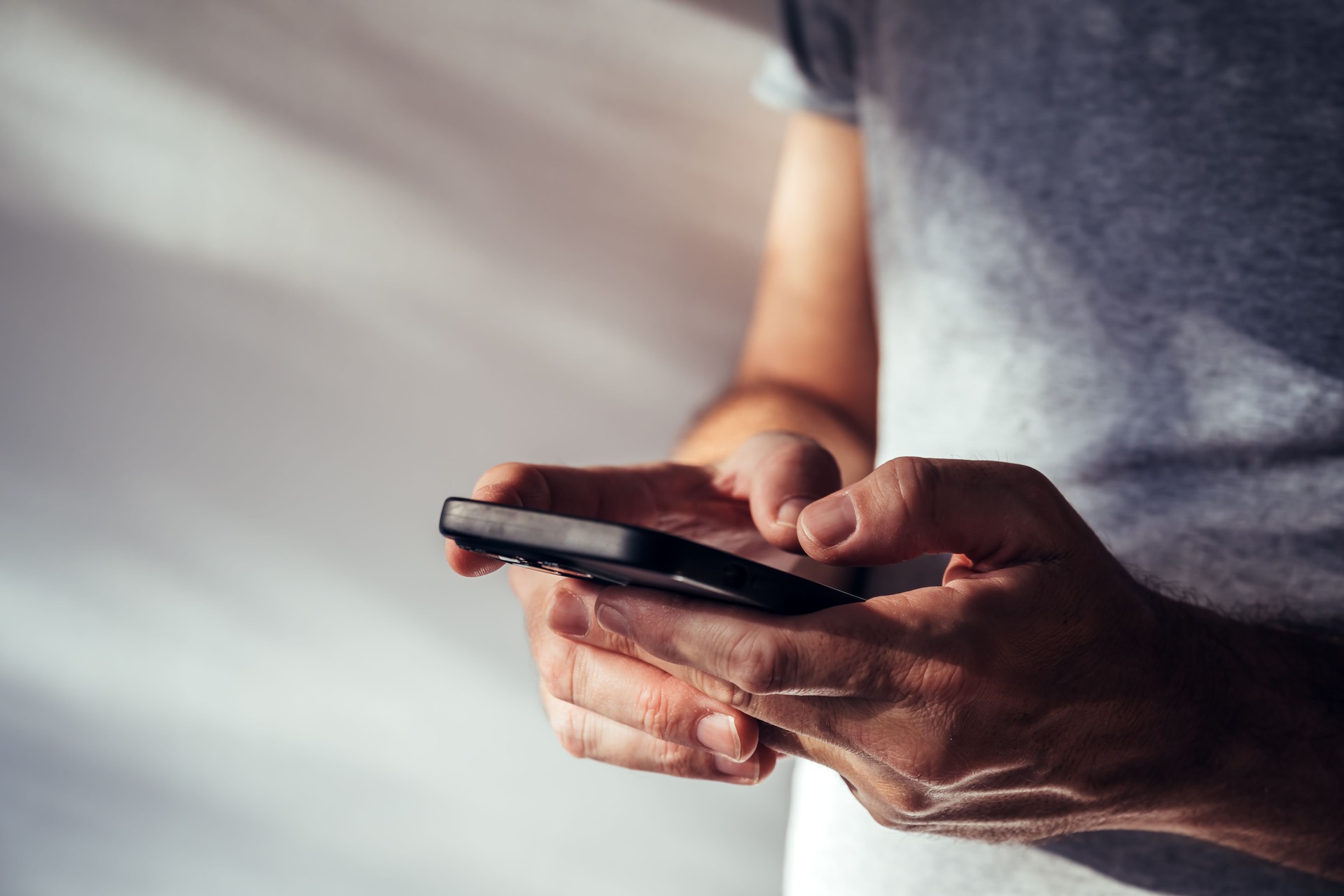 Man using modern smartphone portable information device to type text message